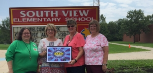 Four people standing in front of South View Elementary School sign