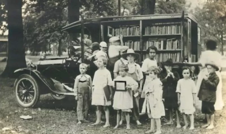 MPL's first book mobile with children standing in front of it.