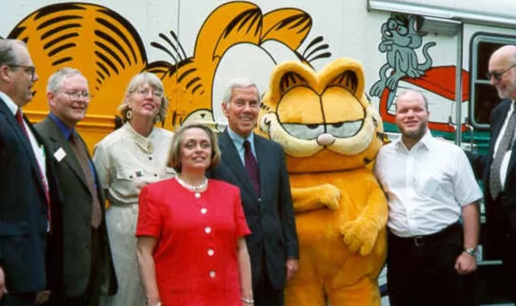 Garfield and library staff in front of the Cybermobile (bookmobile)